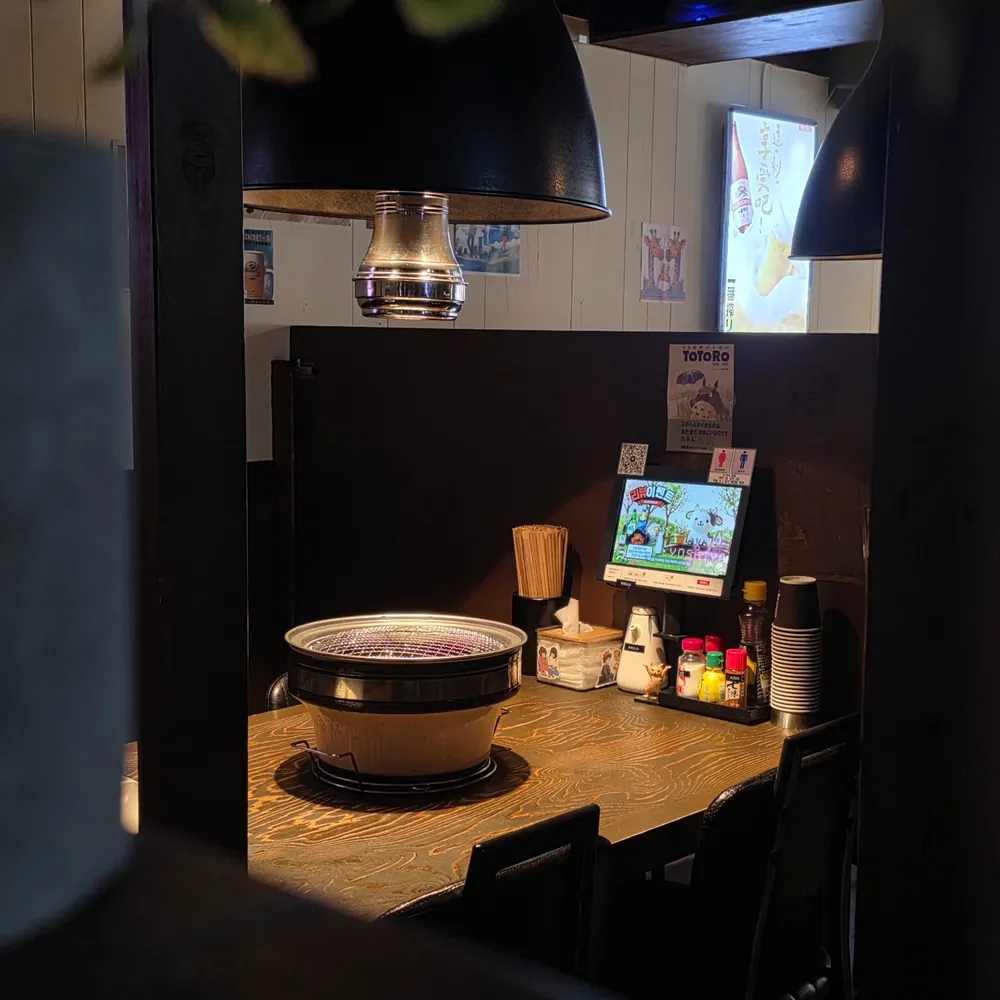 창가 좌석과 숯불 화로가 놓인 매장 내부