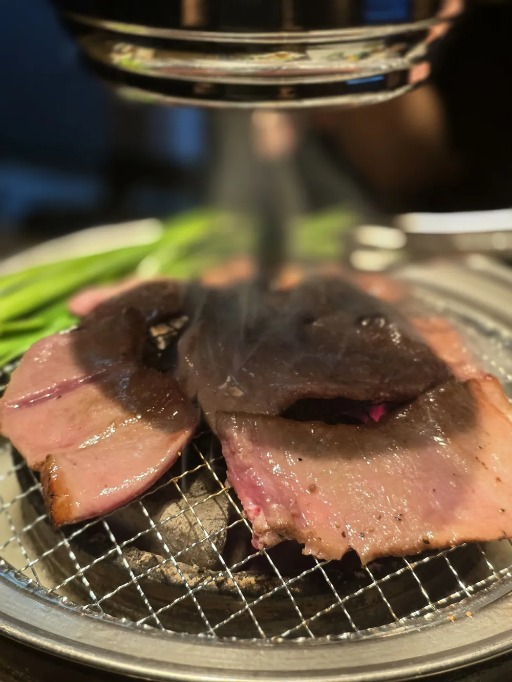 연기가 피어오르는 숯불 화로에서 구워지는 우설